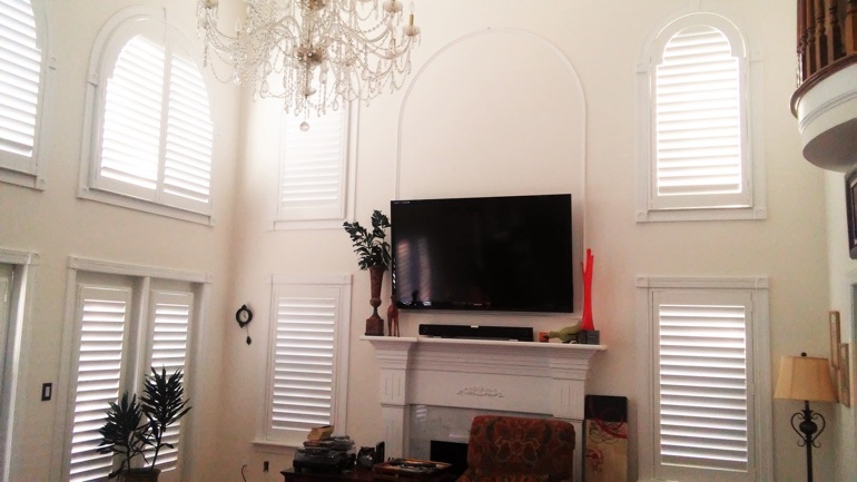 Hartford great room with mounted television and arc windows.